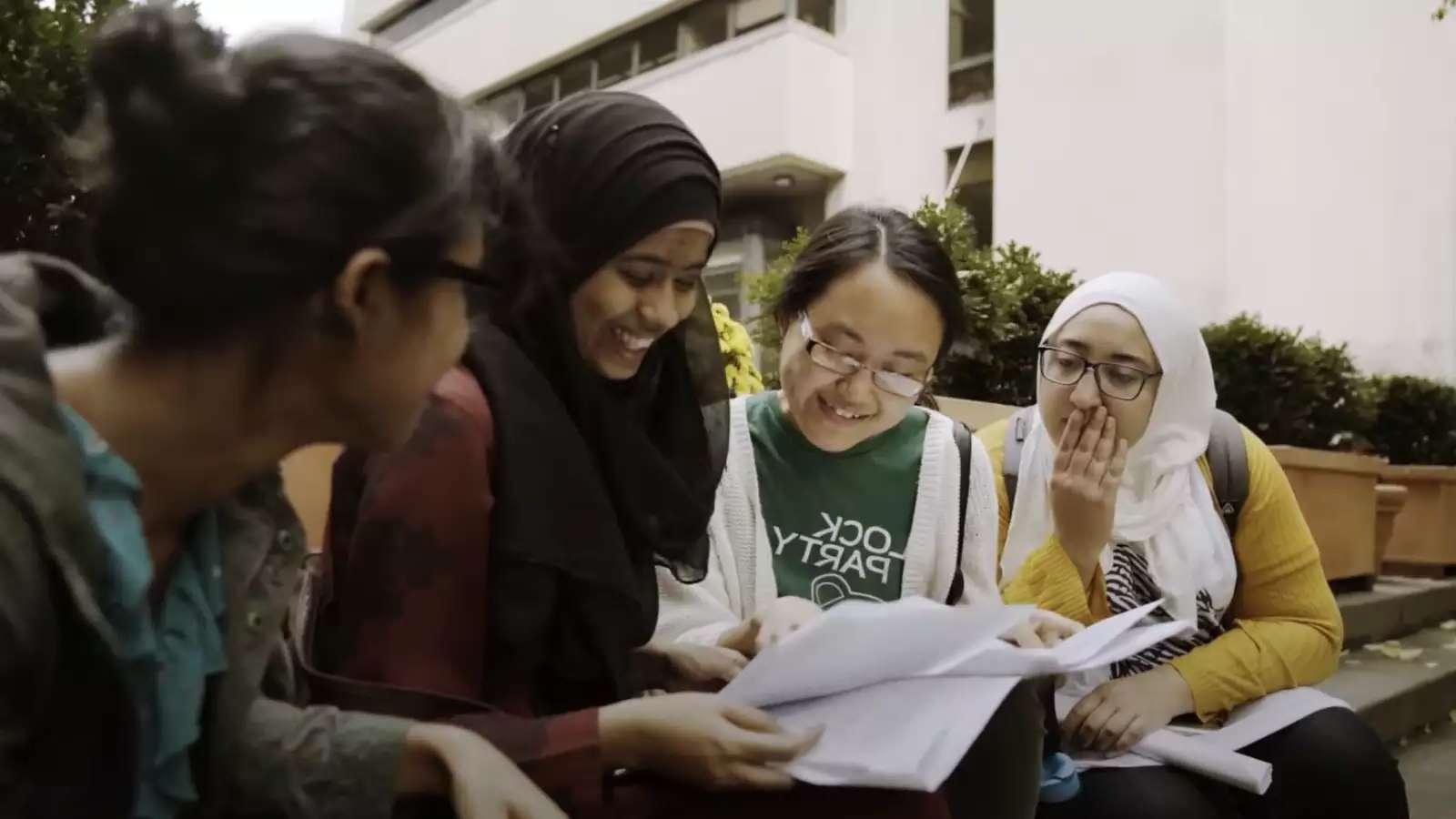 Four Barnard students gathered around papers reading